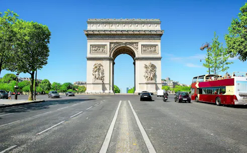 Arc de Triomphe in Paris with nearby tour bus, ideal for Ladurée tea time experience.