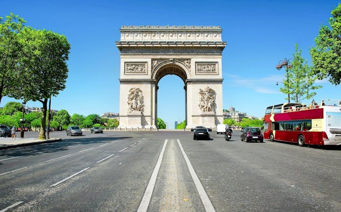 Arc de Triomphe in Paris with nearby tour bus, ideal for Ladurée tea time experience.