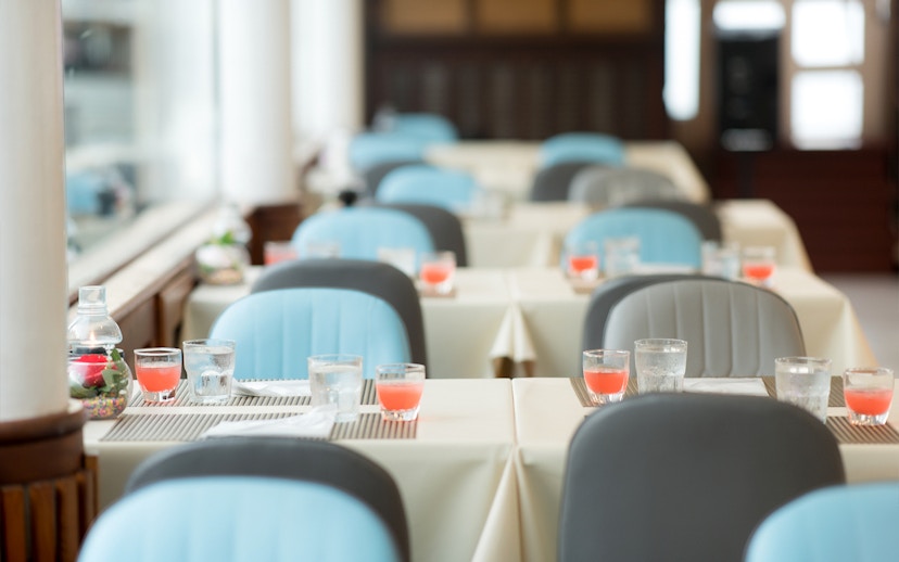 Dining tables set with drinks inside Meridian Cruise, Bangkok.