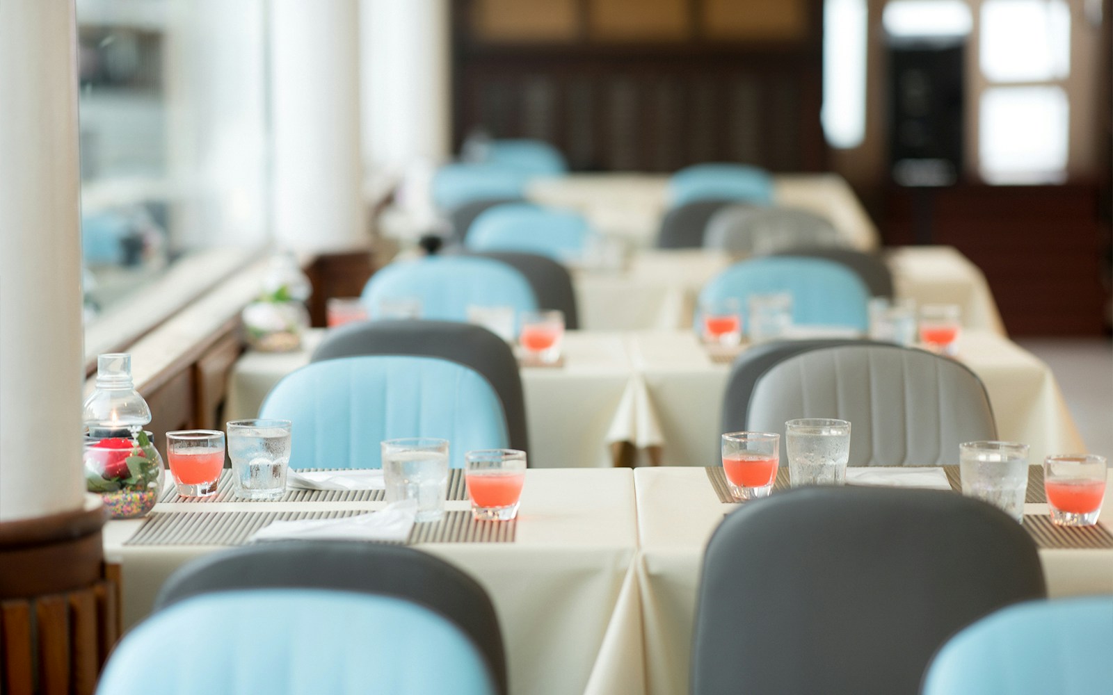 Meridian Cruise dining area with tables set for dinner, Bangkok skyline visible through windows.