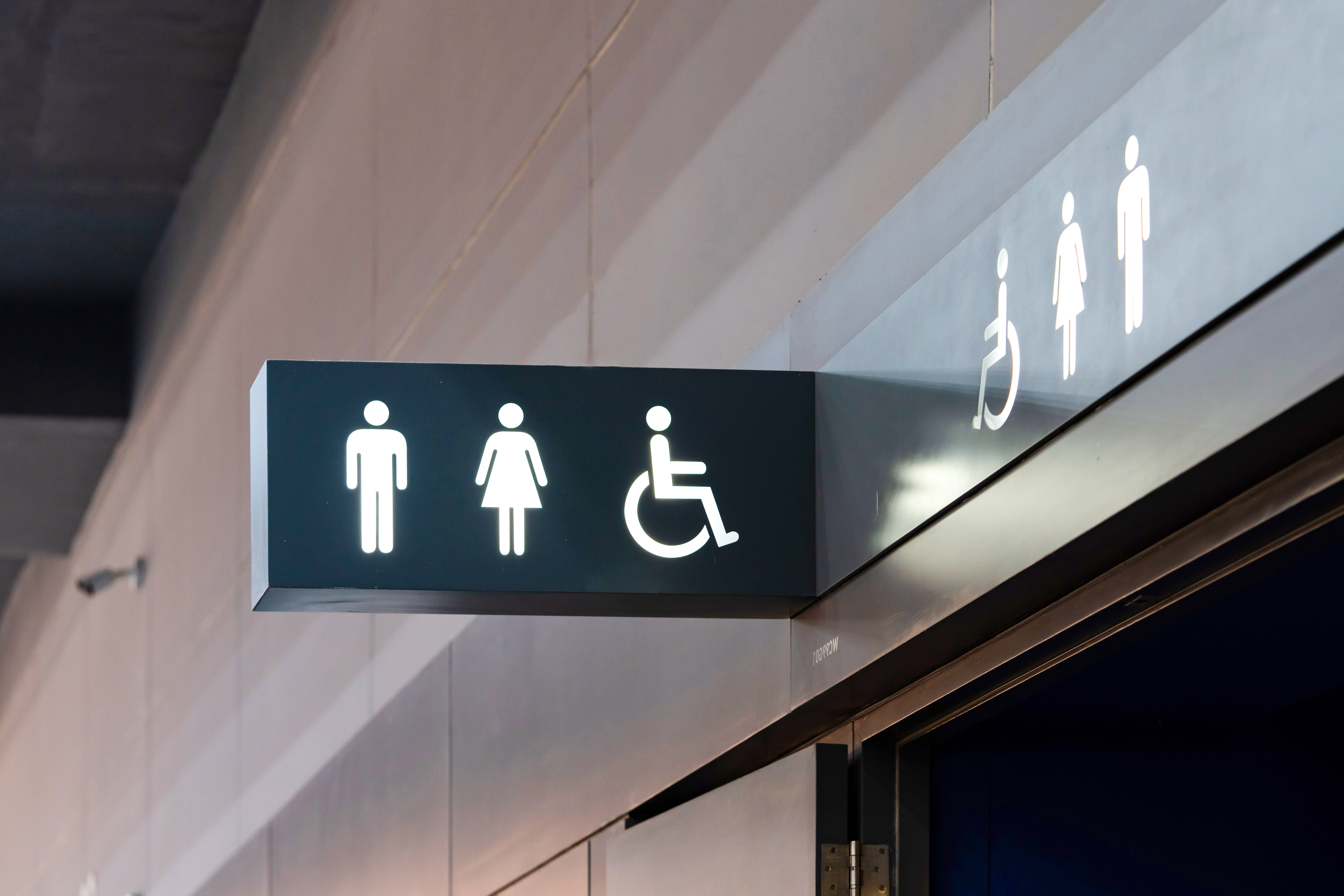 Restroom entrance in American Museum of Natural History with directional signage.