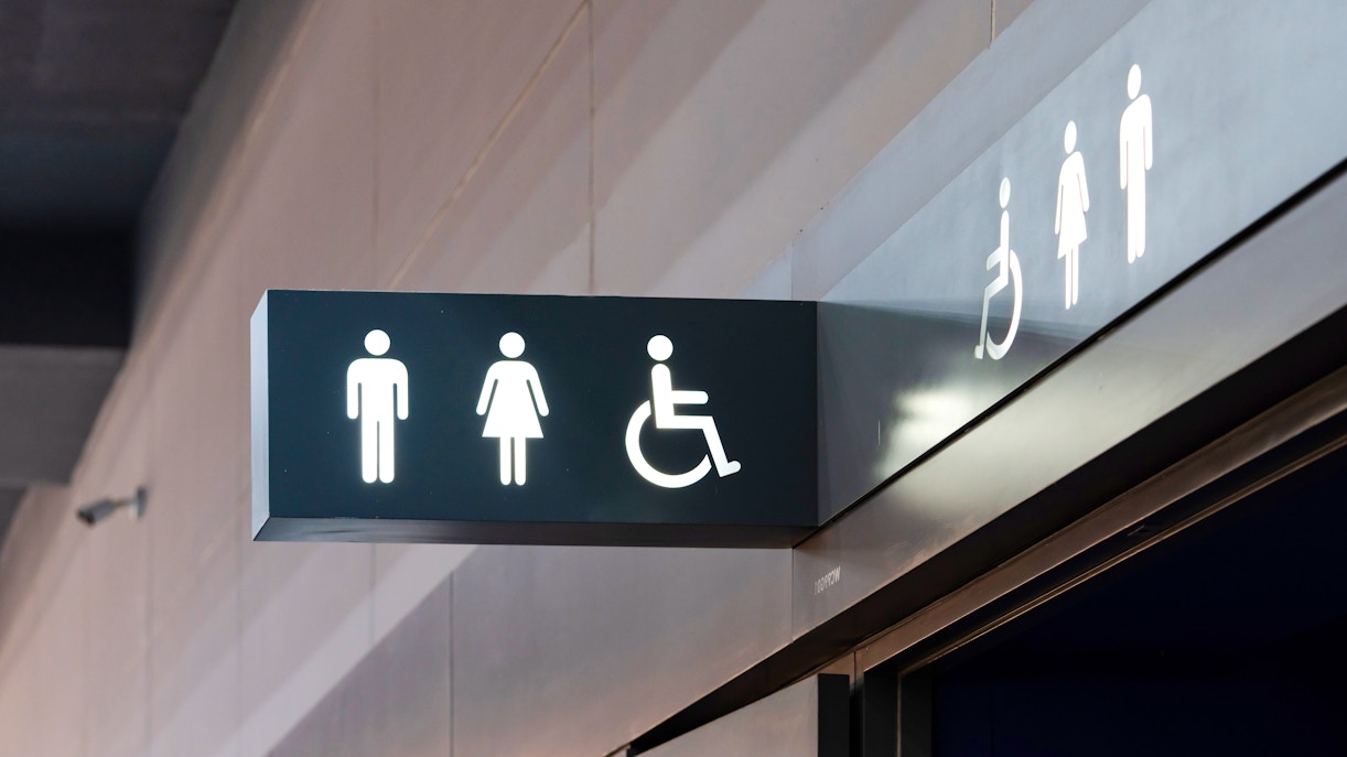 Restroom entrance in American Museum of Natural History with directional signage.