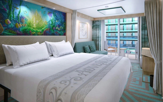 Deluxe room with ocean-themed mural and verandah view.