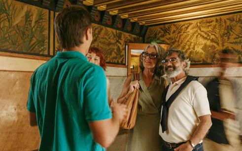 Tour group inside Casa Vicens, Barcelona, with guide explaining wall art.