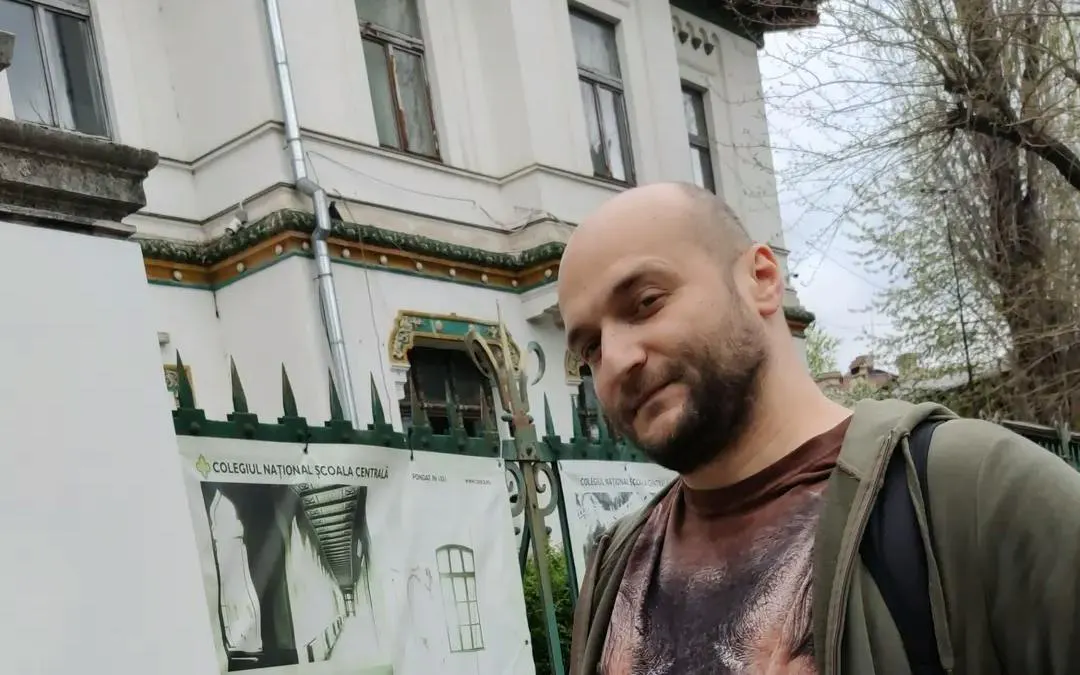 Man standing in front of Colegiul Național Școala Centrală, Bucharest, part of Spy Game tour.