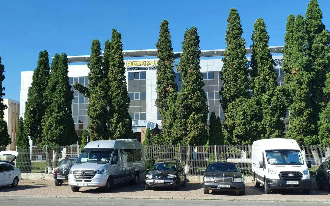 Building in Brașov with parked vehicles, part of the 1987 Workers' Protest self-guided city exploration game.