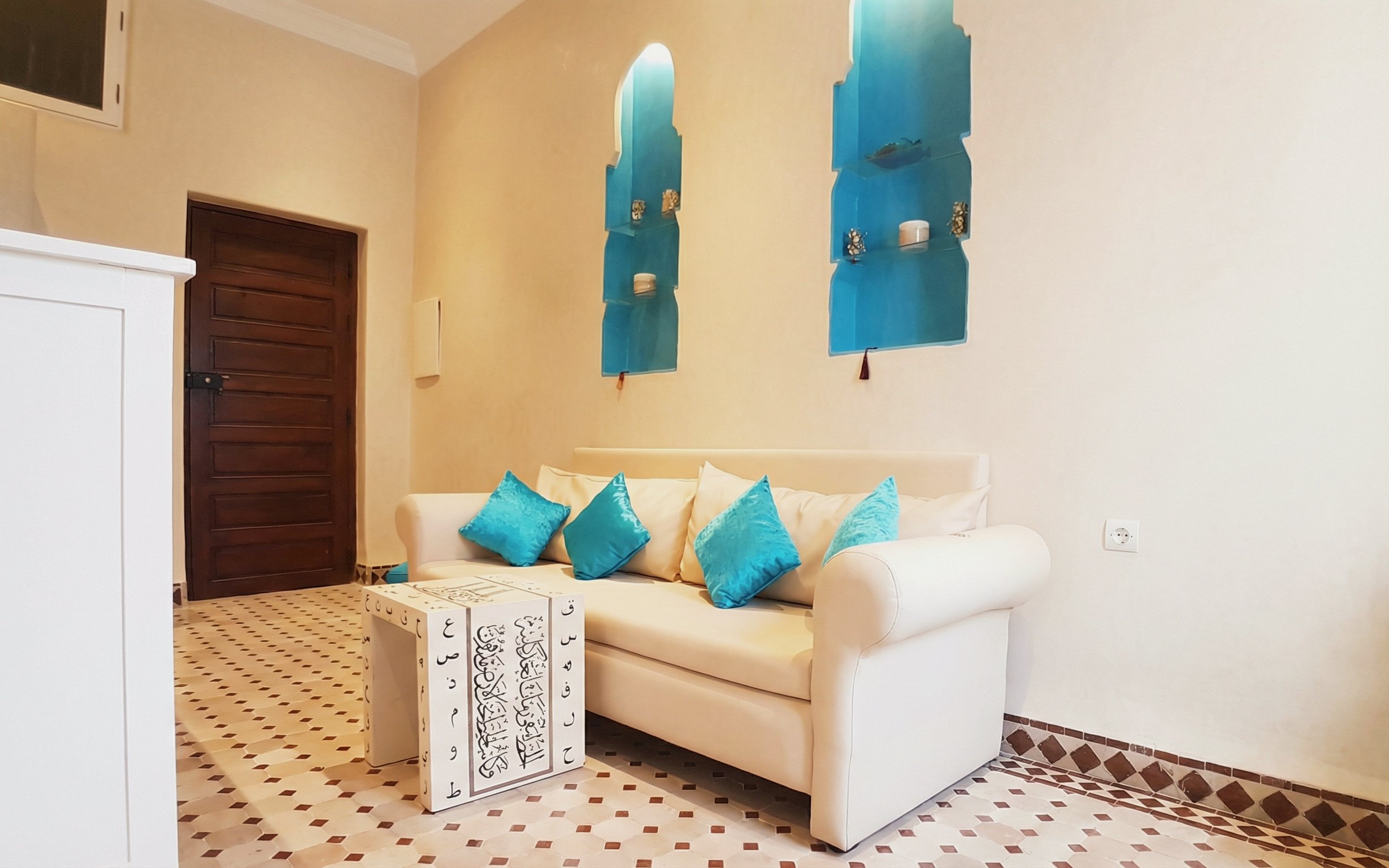 Sofa with blue cushions in waiting area at Moroccan Hammam & Spa, Marrakech.