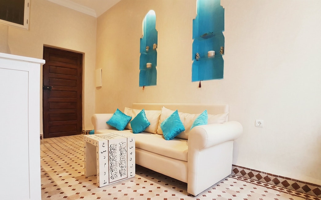 Sofa with blue cushions in waiting area at Moroccan Hammam & Spa, Marrakech.