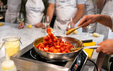 Cooking cherry tomatoes in a pan during a Florence pasta-making class.