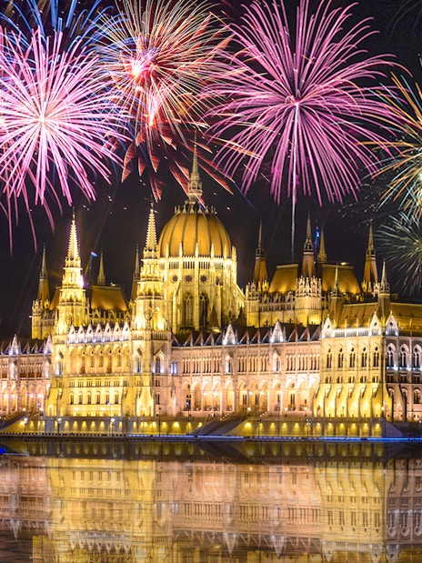 Budapest Parliament with fireworks during New Year's Eve cruise on the Danube.