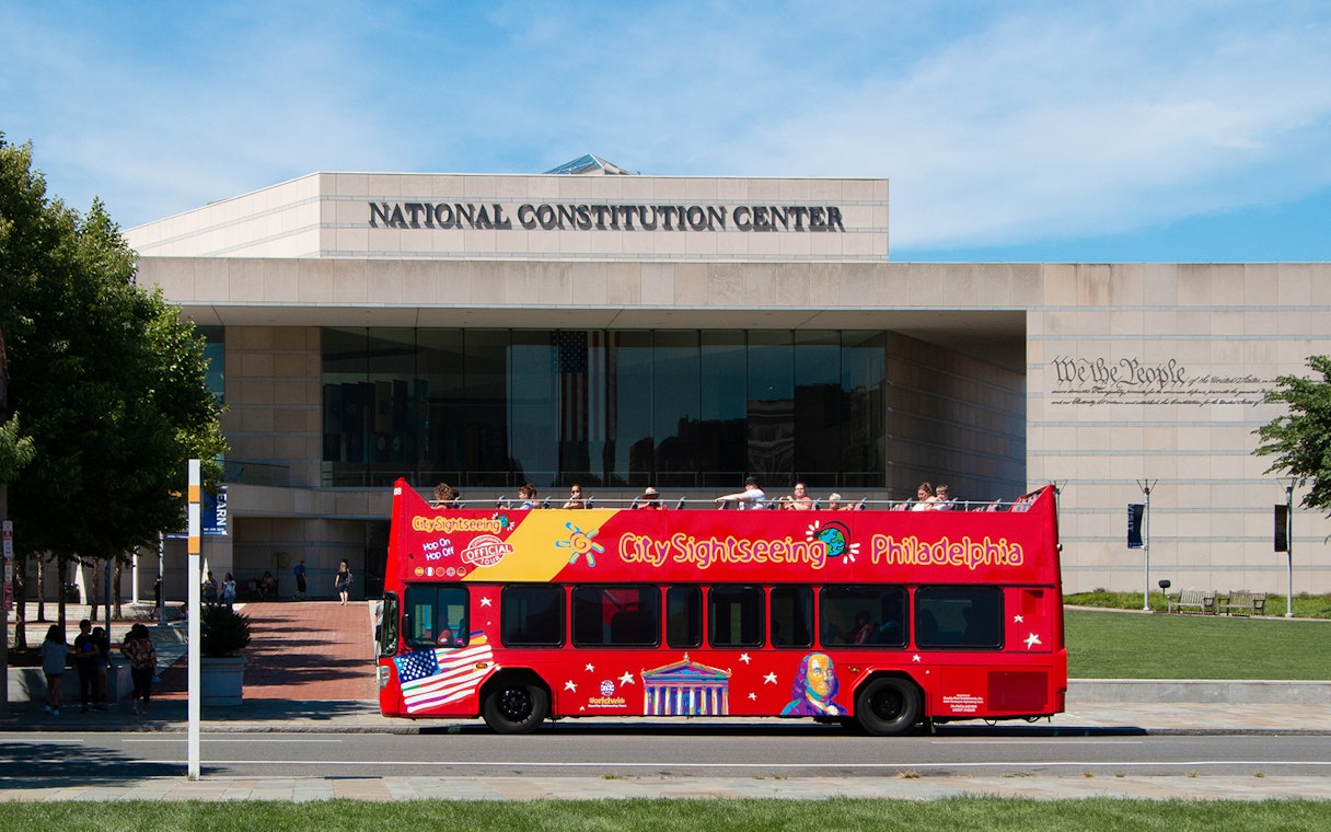 Red double-decker bus in front of the National Constitution Center, Philadelphia Hop-On-Hop-Off Tour.