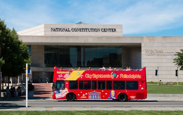 Red double-decker bus in front of the National Constitution Center, Philadelphia Hop-On-Hop-Off Tour.