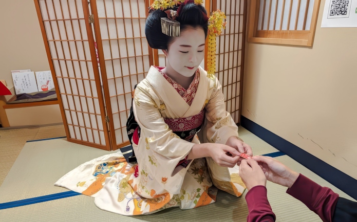 Maiko in traditional kimono performing tea ceremony in Kyoto.