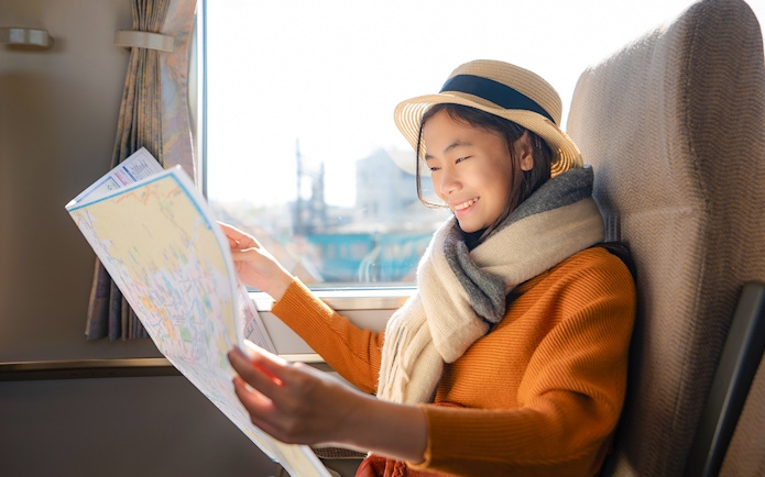 Woman reading a map on a train in Japan.