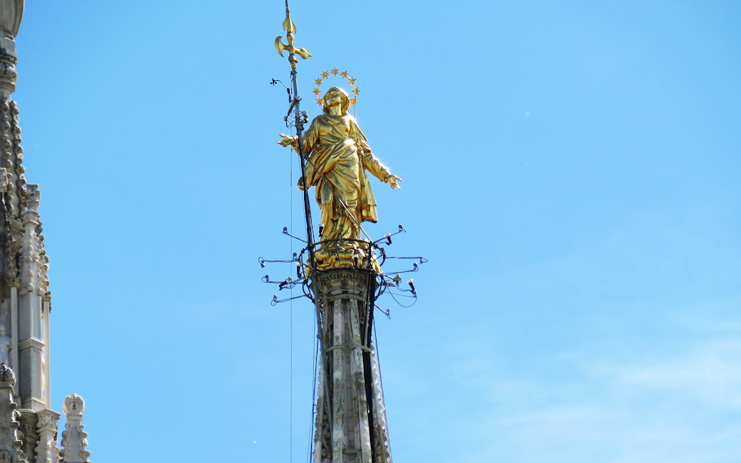 Madonnina statue on Duomo Cathedral rooftop, Milan, with repair scaffolding.