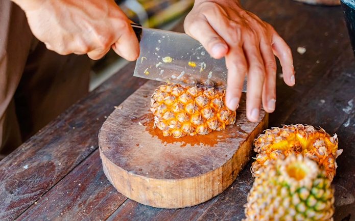 Cutting pineapple for elephants at Phuket Elephant Care.