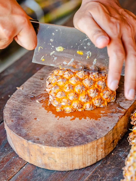 Cutting pineapple for elephants at Phuket Elephant Care.