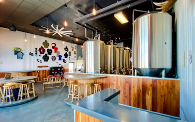 Fairbanks brewery interior with large brewing tanks and seating area.