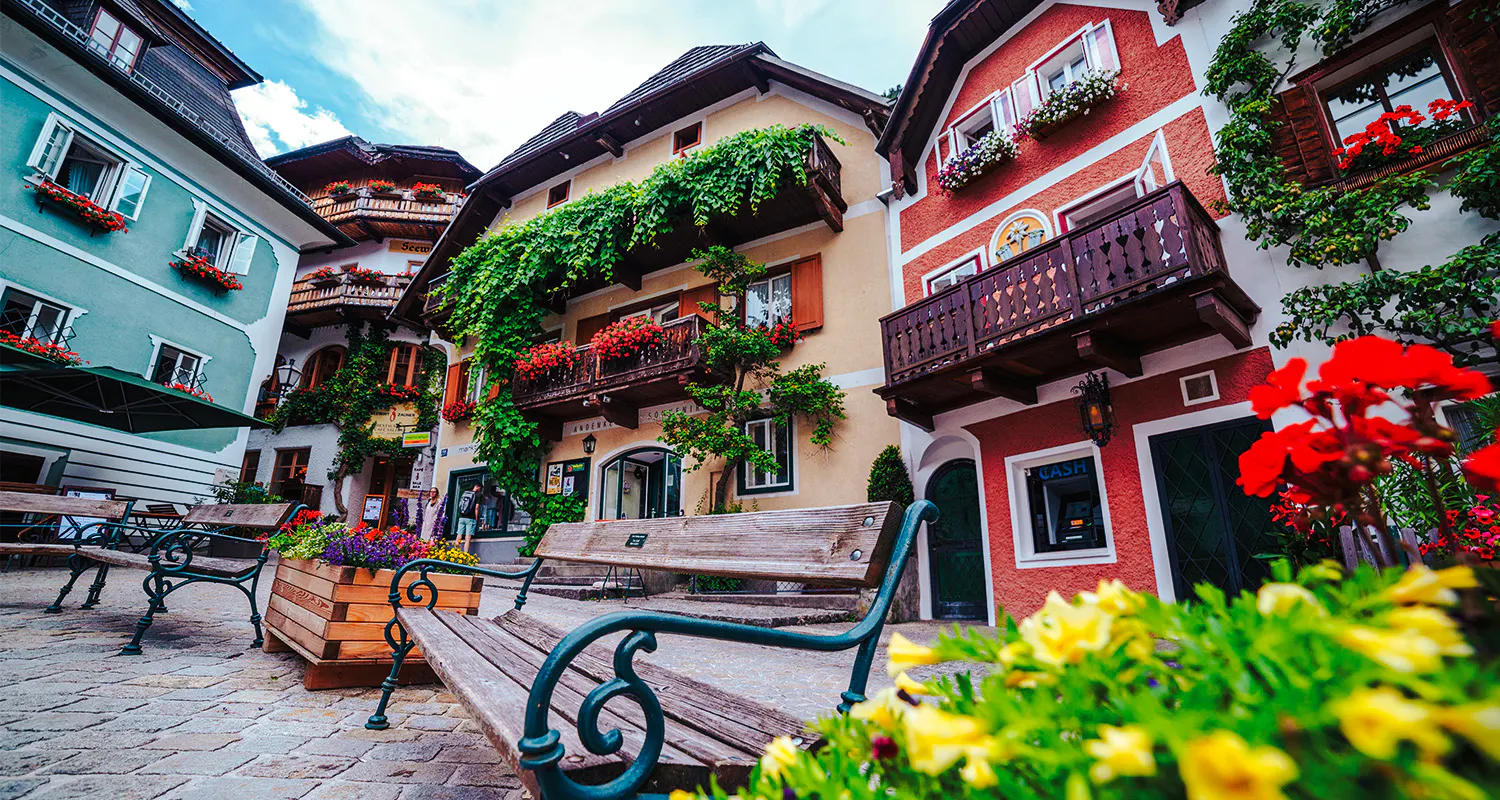 Colorful houses and flower-adorned balconies in Hallstatt, Austria, seen on a day trip from Vienna.