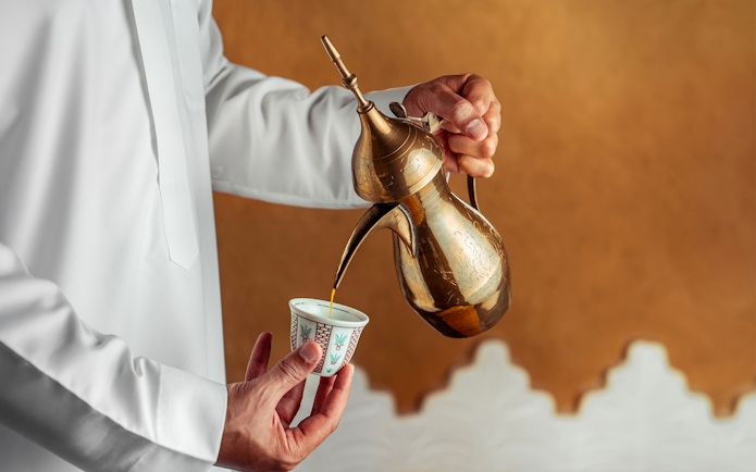 Pouring mint tea from a brass teapot during Agafay Desert quad biking tour.