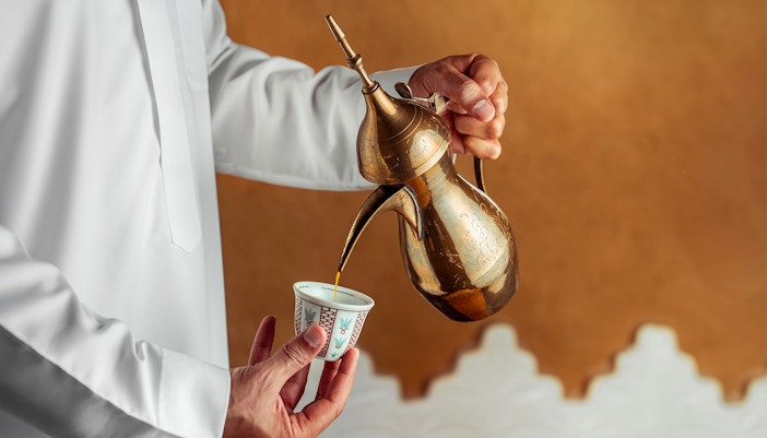 Pouring mint tea from a brass teapot during Agafay Desert quad biking tour.