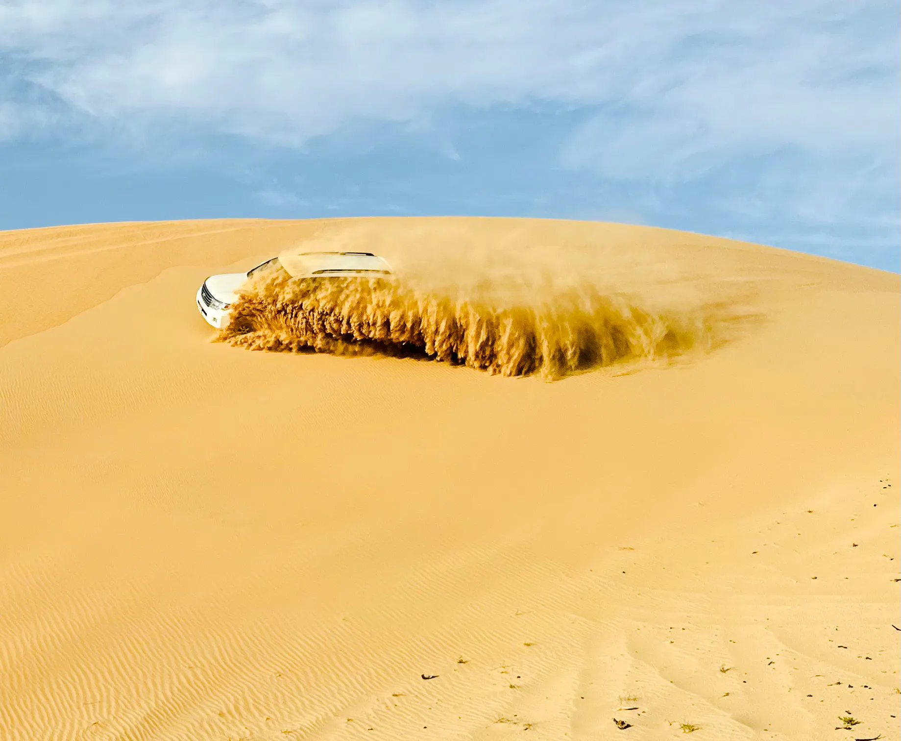 SUV driving through sand dunes during Abu Dhabi desert safari.