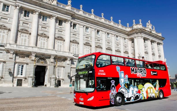 Red Madrid City Tour bus in front of the Royal Palace, Madrid.