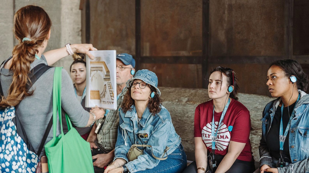 Tour guide showing a diagram to participants at the Colosseum.