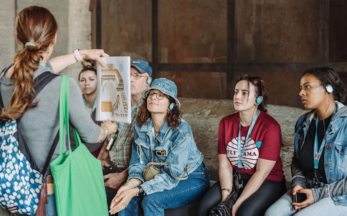 Tour guide showing a diagram to participants at the Colosseum.