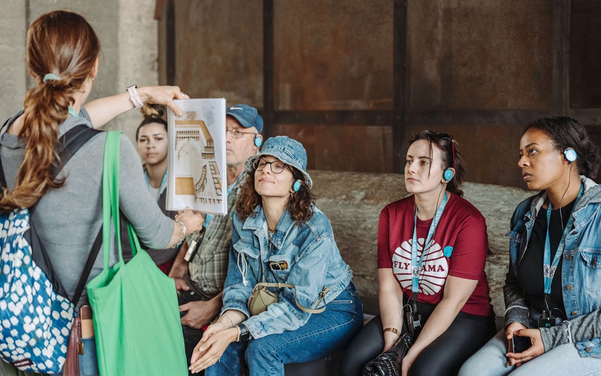 Tour guide showing a diagram to participants at the Colosseum.