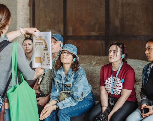 Tour guide showing a diagram to participants at the Colosseum.