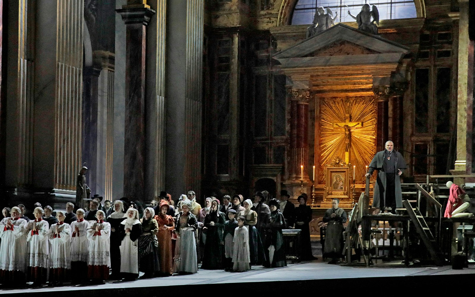 Opera performance of Tosca with a choir and priest in a grand cathedral setting.
