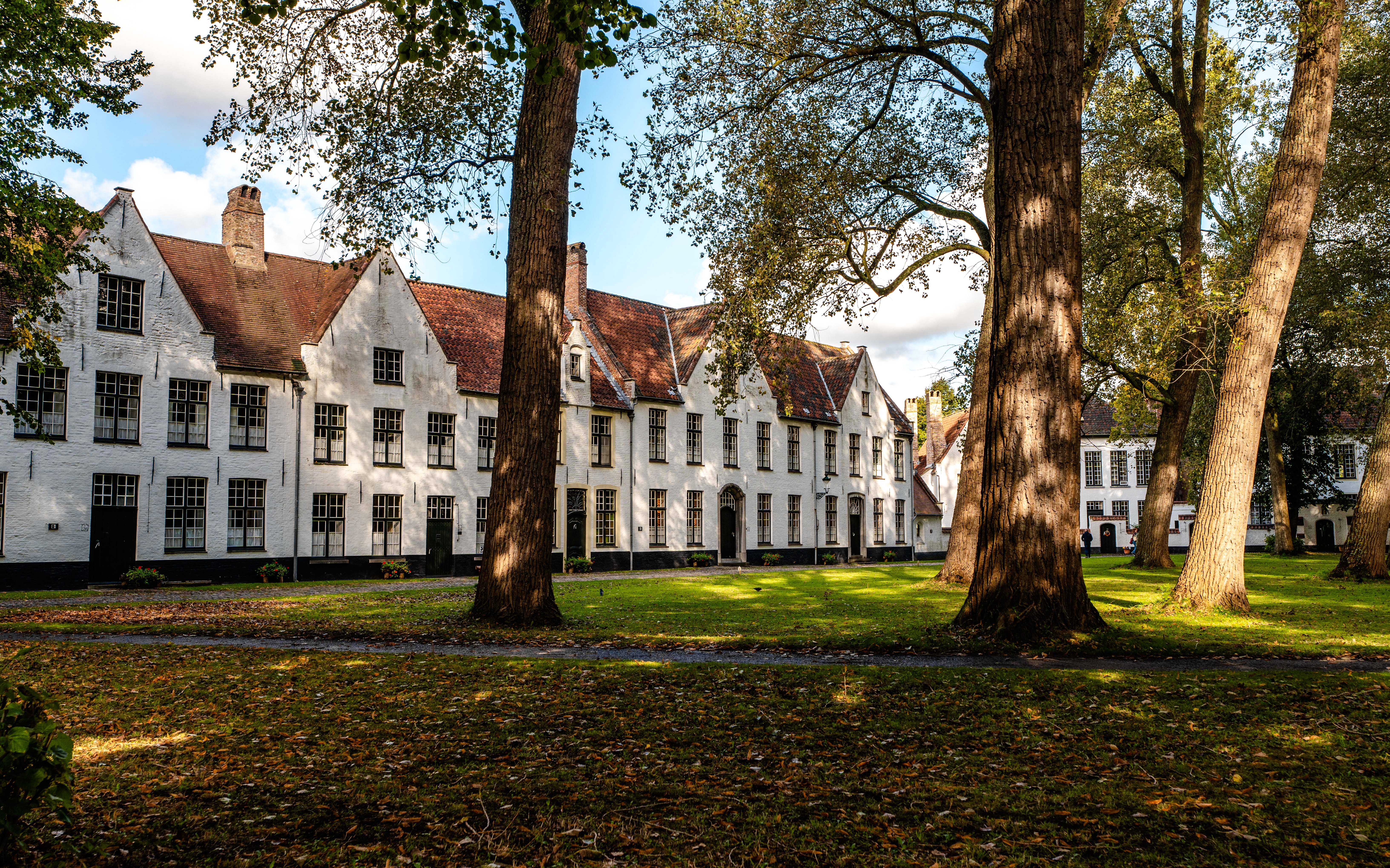 Princely Beguinage Ten Wijngaerde courtyard with historic white buildings in Bruges, Belgium.
