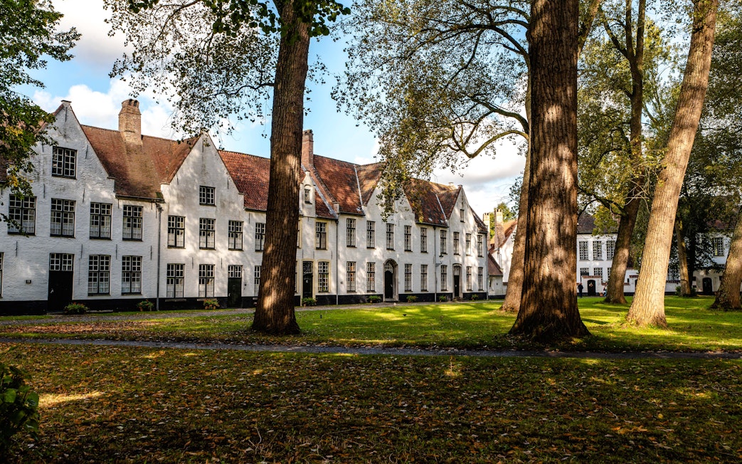 Princely Beguinage Ten Wijngaerde courtyard with historic white buildings in Bruges, Belgium.