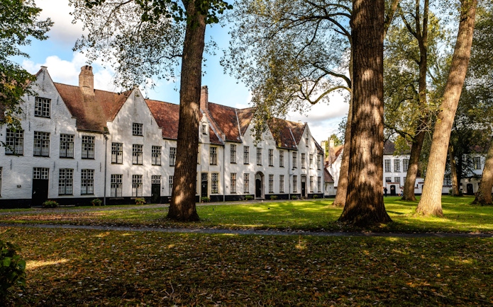 Princely Beguinage Ten Wijngaerde courtyard with historic white buildings in Bruges, Belgium.