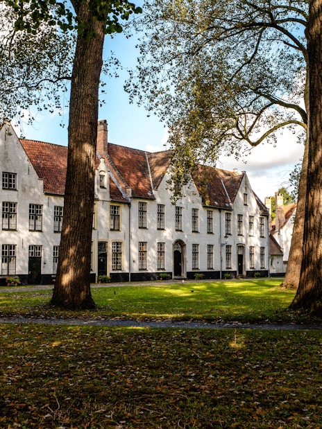 Princely Beguinage Ten Wijngaerde courtyard with historic white buildings in Bruges, Belgium.