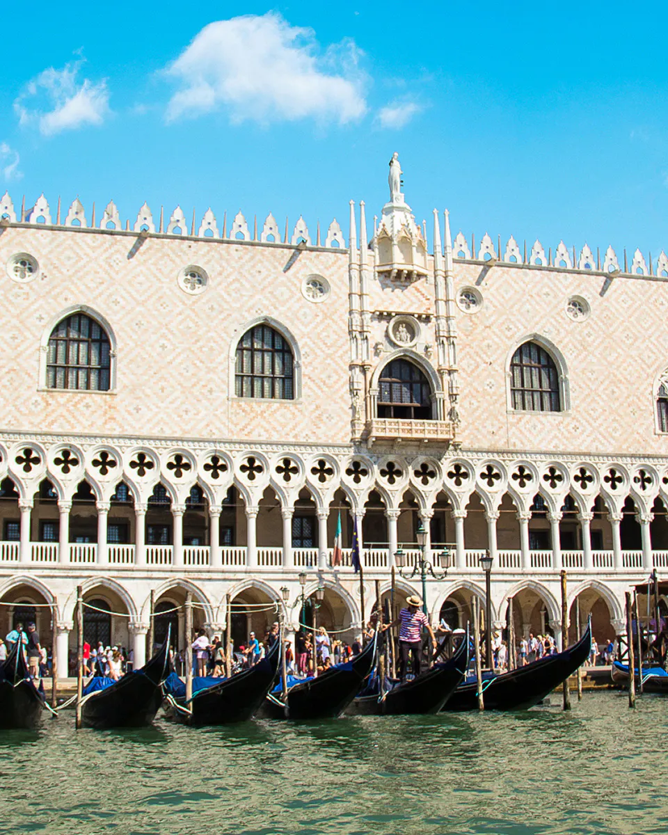 Gondolas in front of Doge's Palace exterior in Venice, Italy.