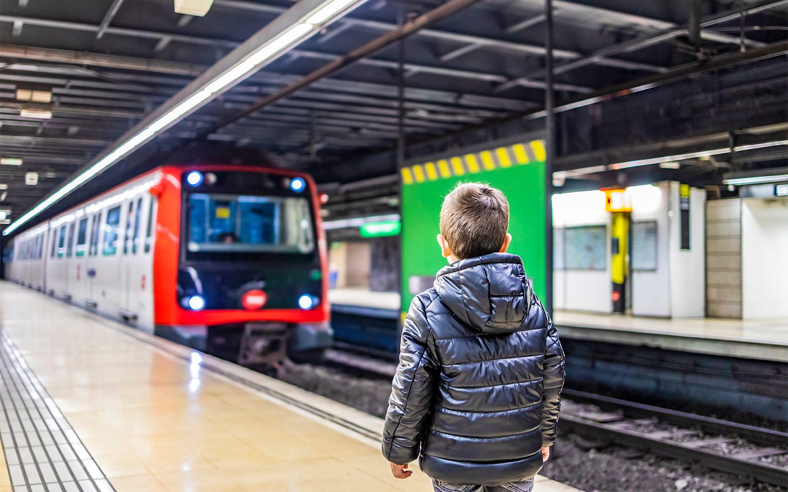 Child holding Barcelona Travel Card with cityscape in the background.