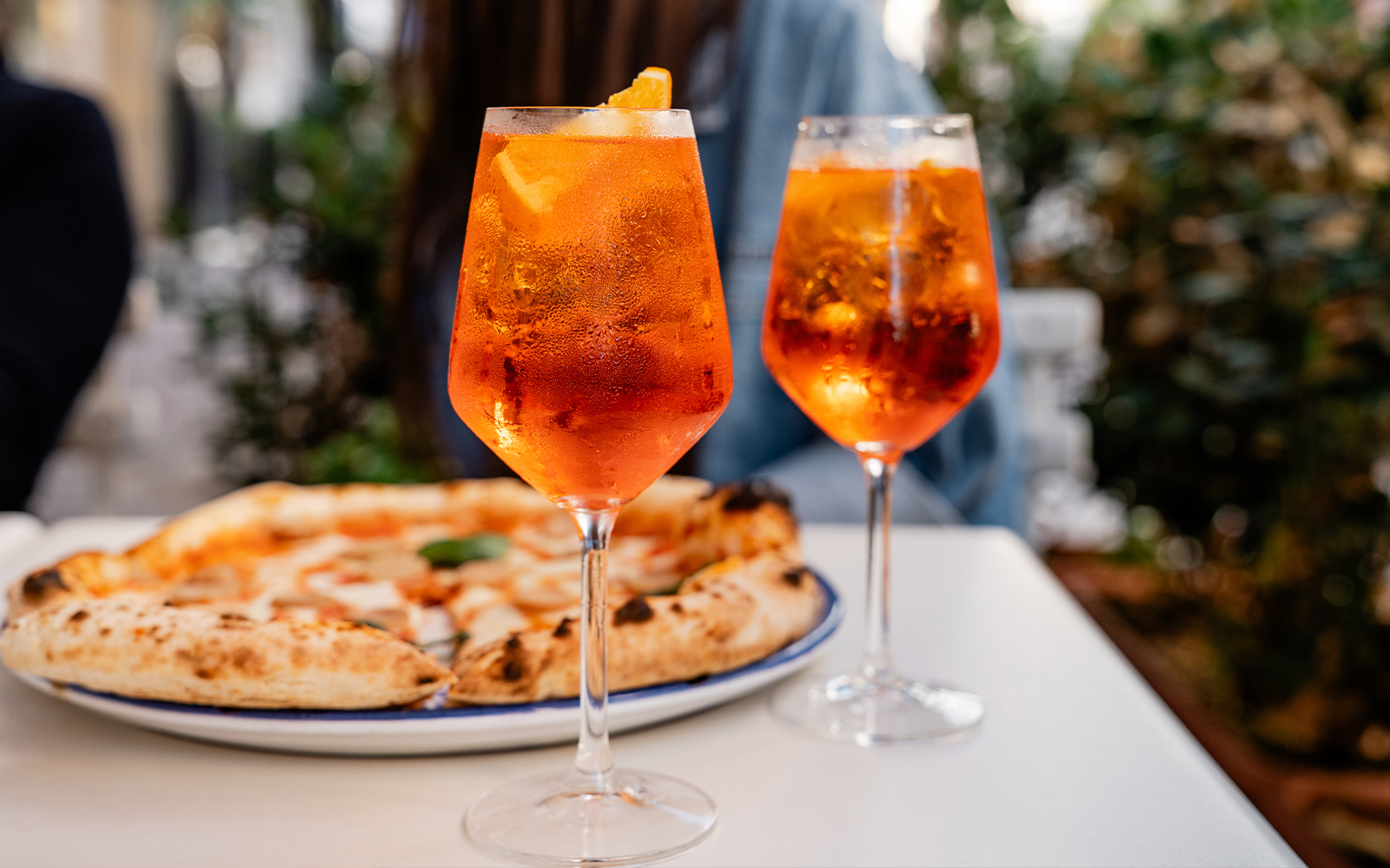 Spritz cocktails and gourmet pizza at a cafe in Rome.