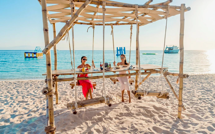Beachside dining setup with swings on Orange Bay, Giftun Island, Hurghada.