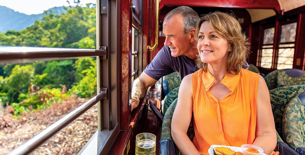 Kuranda Railway Gold Class passengers enjoying scenic view and refreshments, Cairns.