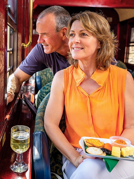 Kuranda Railway Gold Class passengers enjoying scenic view and refreshments, Cairns.