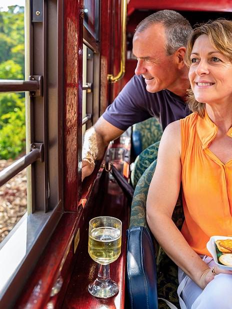 Kuranda Railway Gold Class passengers enjoying scenic view and refreshments, Cairns.