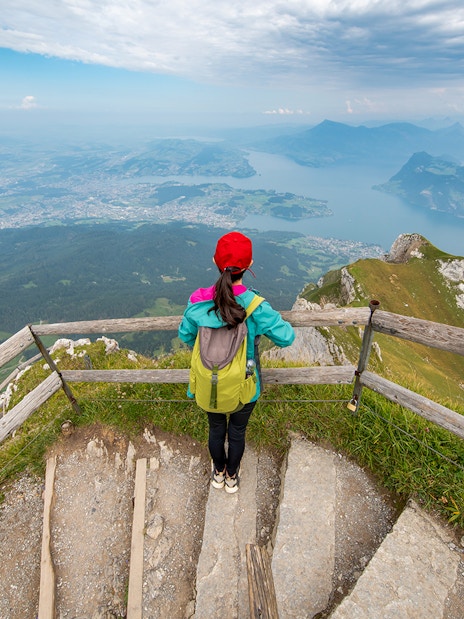 Tourist overlooking Lake Lucerne from Mt. Pilatus summit, Switzerland.
