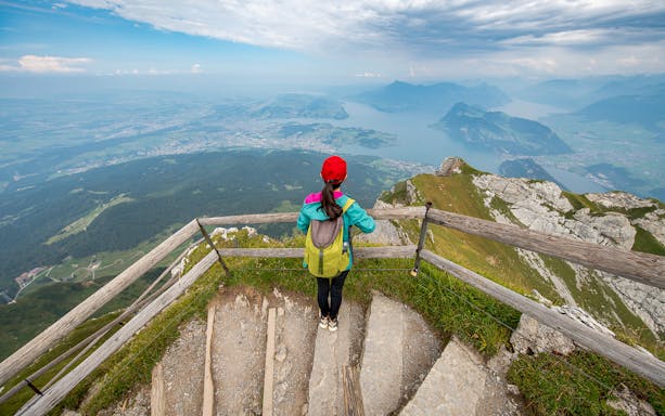 Tourist overlooking Lake Lucerne from Mt. Pilatus summit, Switzerland.