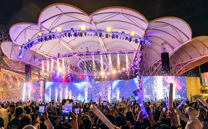 Crowd enjoying a vibrant night show with fireworks at Global Village Dubai.