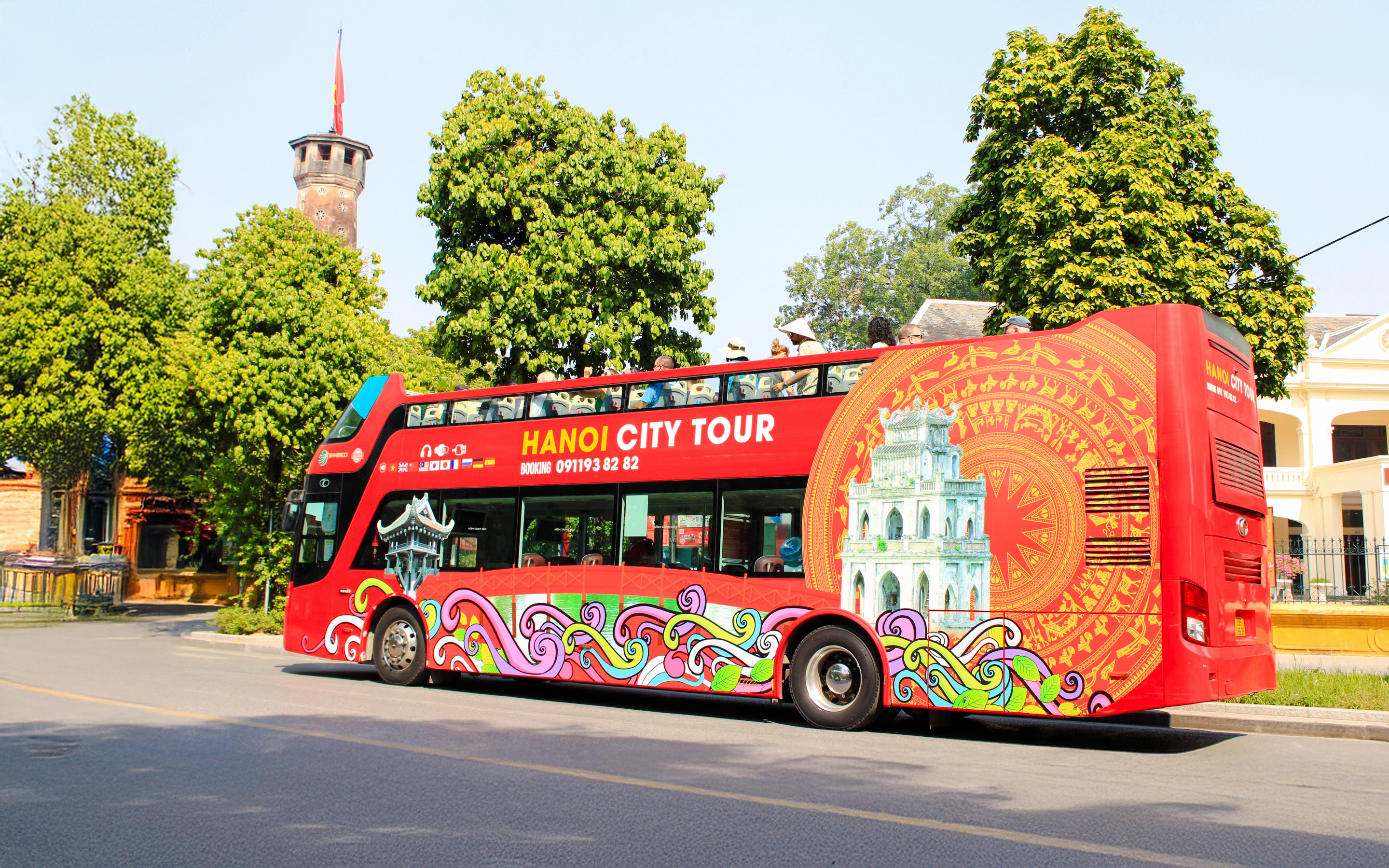 Hop on hop off tour bus in Hanoi, Vietnam with colorful design and city landmarks.