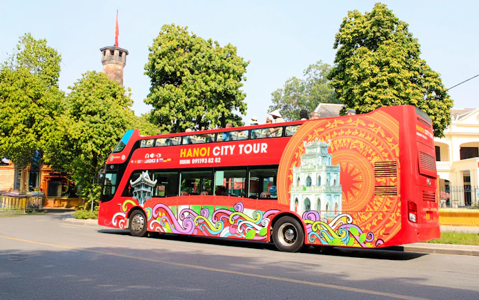 Hop on hop off tour bus in Hanoi, Vietnam with colorful design and city landmarks.
