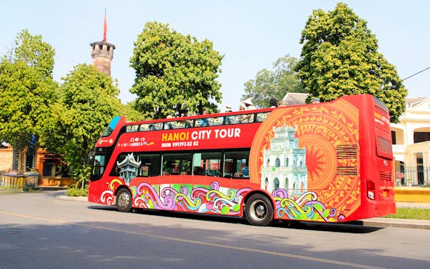 Hop on hop off tour bus in Hanoi, Vietnam with colorful design and city landmarks.