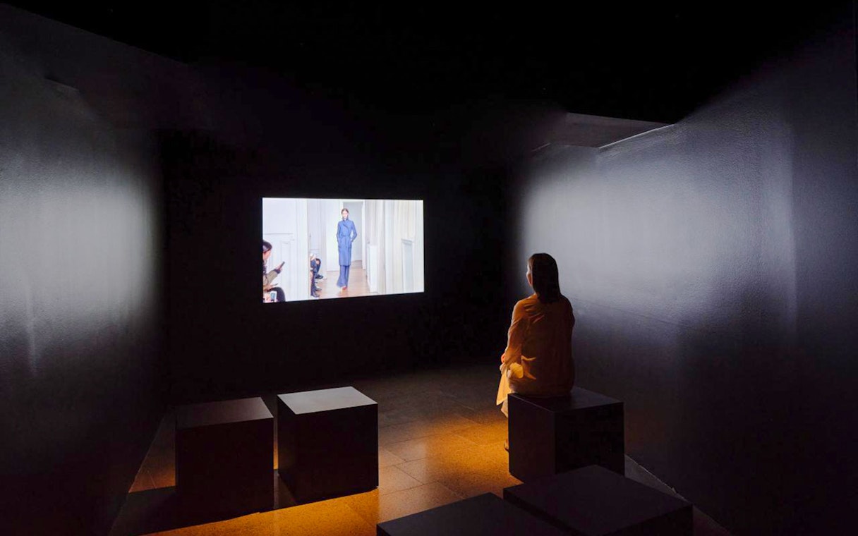 Visitor watching a short film at Martin Grant exhibit.